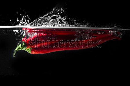 Red hot chili pepper splashing into water Stock photo © deandrobot