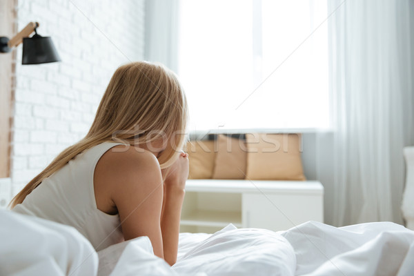 Back view of woman lying on bed in bedroom Stock photo © deandrobot