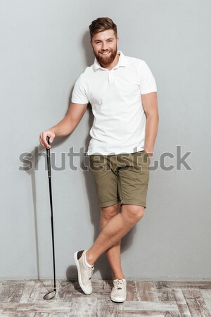 Attractive young dark skinned man sitting over white background Stock photo © deandrobot