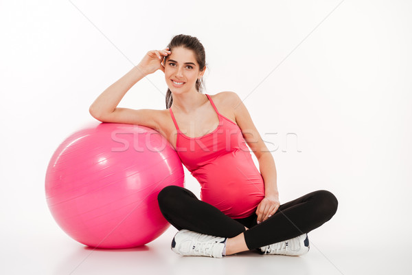 Beautiful young pregnant woman sitting with fitball Stock photo © deandrobot