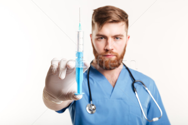 Close up portrait of a serious surgeon holding a syringe Stock photo © deandrobot