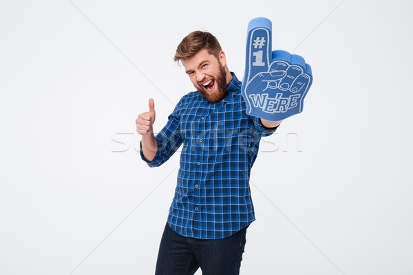 Young man winner showing thumb up and fan finger isoloated Stock photo © deandrobot