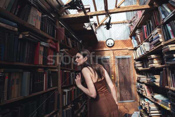 Young woman searching book in library Stock photo © deandrobot