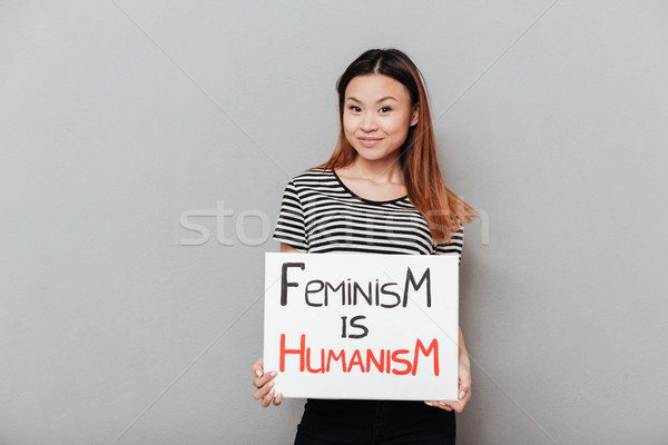 Smiling asian woman holding poster with slogan Stock photo © deandrobot