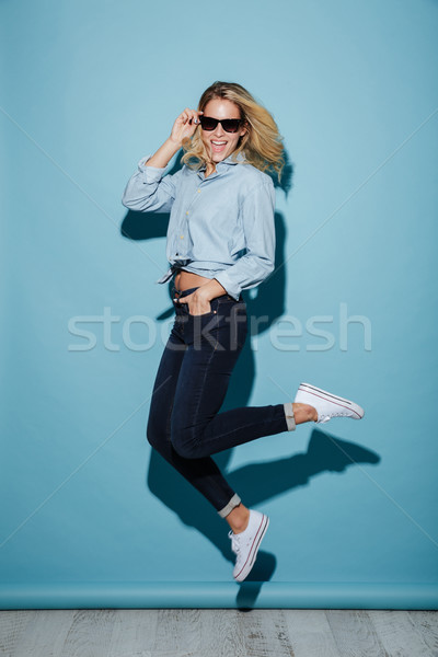 Full length image of Happy woman in shirt and sunglasses Stock photo © deandrobot