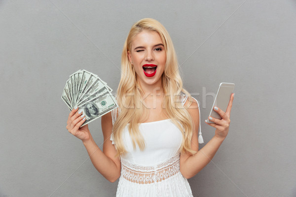 Portrait of a cheery woman holding mobile phone Stock photo © deandrobot