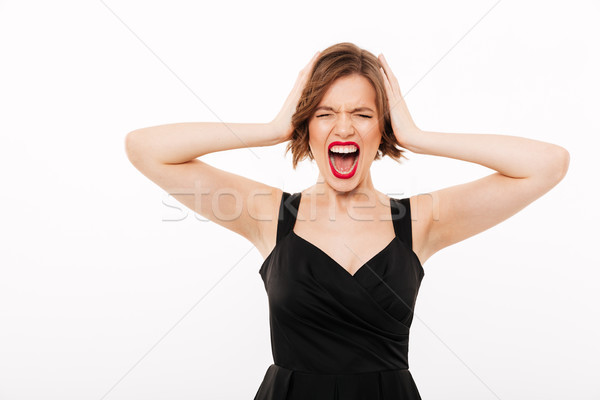 Portrait of a frustrated girl dressed in black dress screaming Stock photo © deandrobot