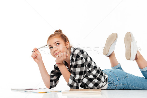 Thoughtful ginger woman in shirt and jeans lying on floor Stock photo © deandrobot