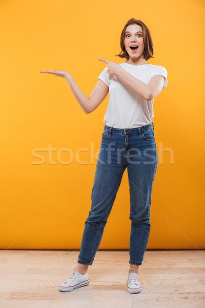 Excited emotional young woman showing copyspace. Stock photo © deandrobot