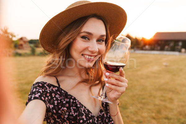 Stock photo: Woman outdoors holding glass drinking wine.