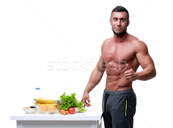 Stock photo: Happy muscular man standing with thumbs up near healthy food