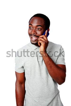 Happy african man talking on the phone isolated on a white background Stock photo © deandrobot