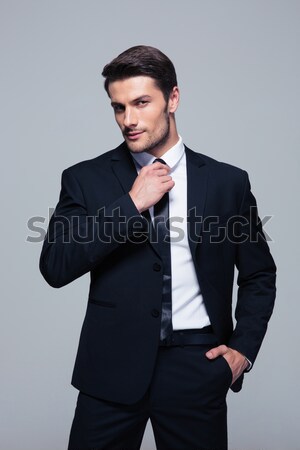 Handsome businessman straightening his tie Stock photo © deandrobot