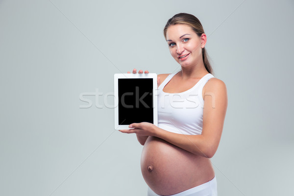 Pregnant woman showing tablet computer screen Stock photo © deandrobot