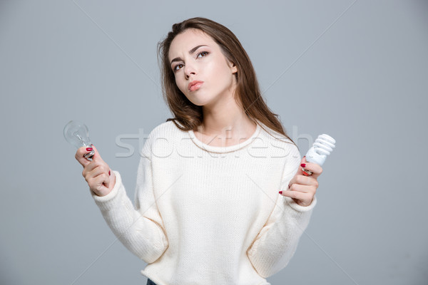 Woman holding two bulbs Stock photo © deandrobot