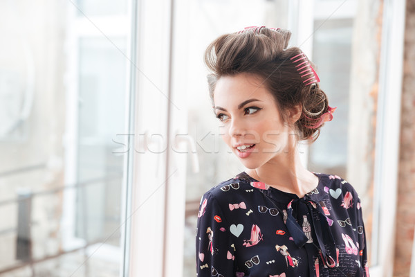 Smiling beautiful young woman with curlers  Stock photo © deandrobot