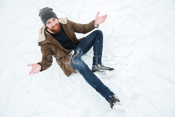 Man sitting on the snow in ice skates  Stock photo © deandrobot