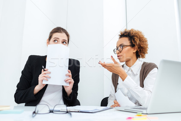 Strict african businesswoman director talking with her scared young employee  Stock photo © deandrobot