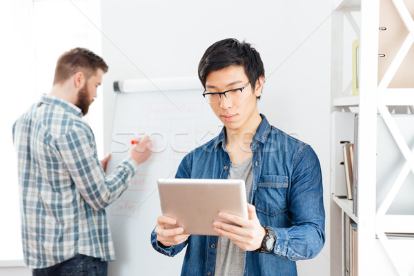 Stockfoto: Twee · zakenlieden · werken · tablet · flipchart · kantoor