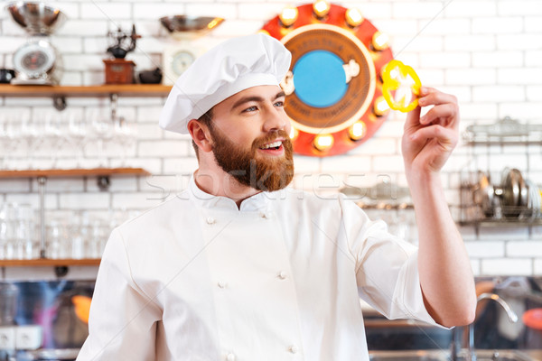 Smiling cook cheif holding slice of yellow bell pepper  Stock photo © deandrobot