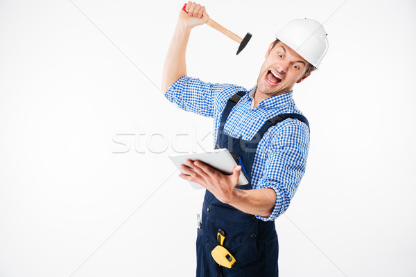 Portrait of a screaming builder trying to break pc tablet Stock photo © deandrobot