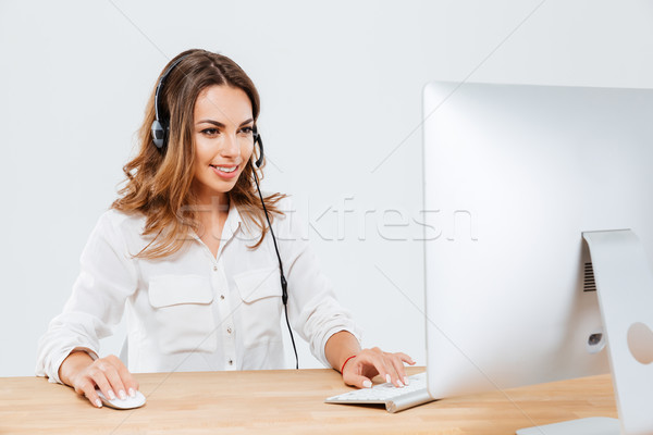 Happy woman working on laptop computer in call center Stock photo © deandrobot