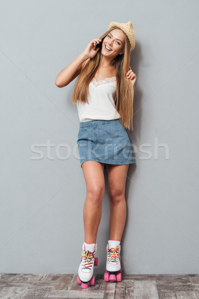 Girl in hat and roller skates talking on the phone Stock photo © deandrobot
