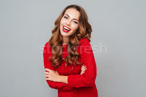 Cheerful beautiful young woman in red sweater Stock photo © deandrobot