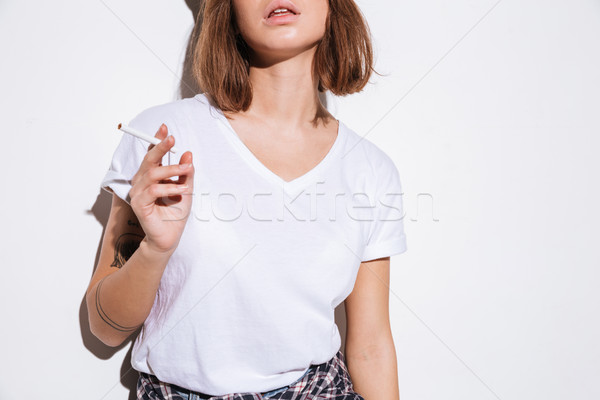 Photos femme cigarette blanche tshirt permanent Photo stock © deandrobot