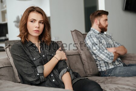 Sad quarrel loving couple sitting on sofa indoors. Stock photo © deandrobot