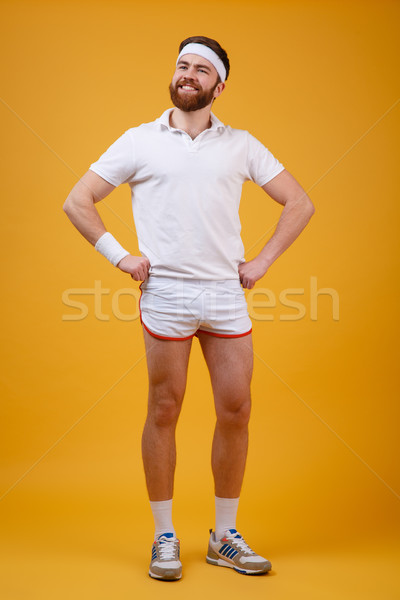 Vertical image of pleased sportsman holding arms at hip Stock photo © deandrobot