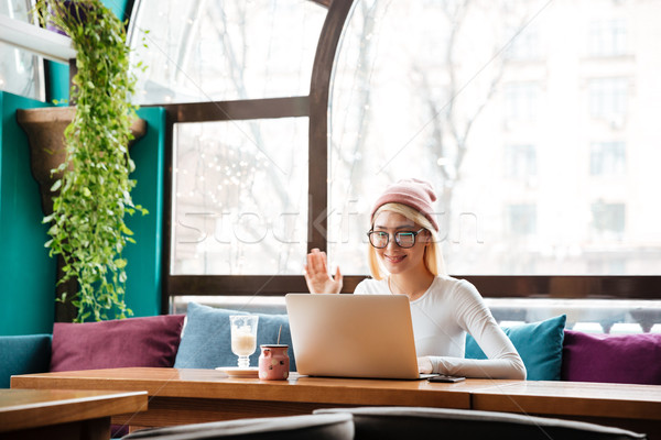 Stock photo: Happy woman using laptop computer for video chat in cafe