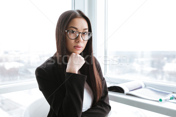 Serious businesswoman standing near the window in office Stock photo © deandrobot