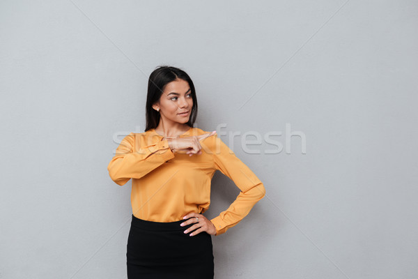 Stock photo: Portrait of a smiling excited businesswoman pointing finger away