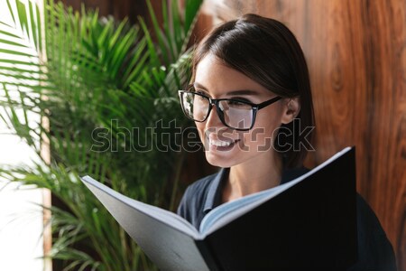 Pretty business woman in eyeglasses sitting by the table Stock photo © deandrobot