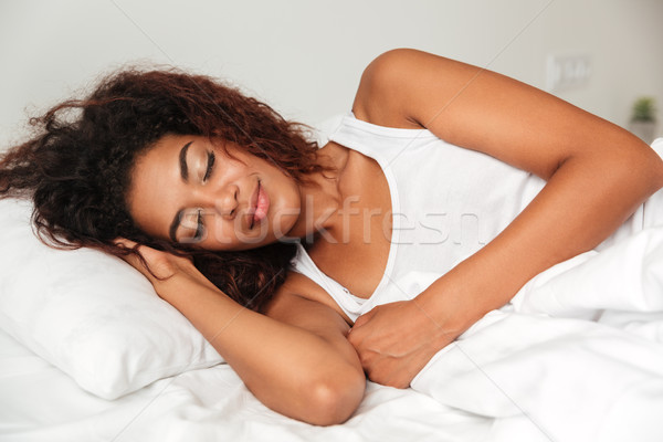 Jeunes calme femme pyjama dormir lit Photo stock © deandrobot