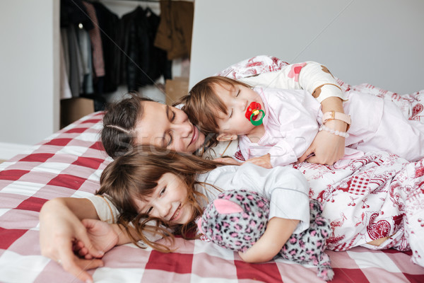 Young pretty woman lying with her children Stock photo © deandrobot
