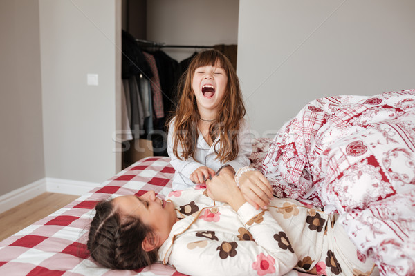 Little girl laughing in bedroom Stock photo © deandrobot