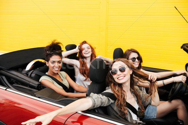 Happy emotional four young women friends sitting in car Stock photo © deandrobot
