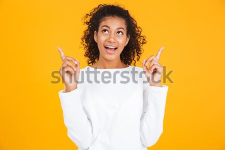 Portrait of a cheery little african girl listening to music Stock photo © deandrobot