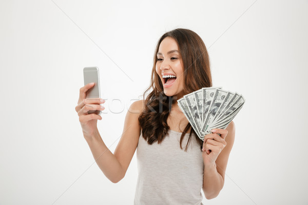 Portrait of happy joyous female 30s demonstrating lots of money  Stock photo © deandrobot