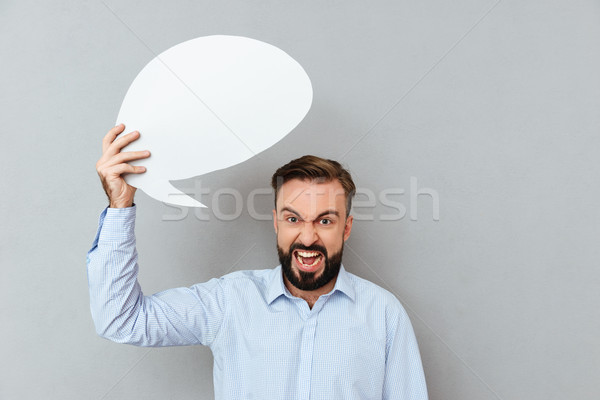 Stock photo: Angry bearded man in business clothes holding blank speech bubble