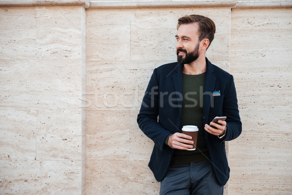 Portrait of a handsome smiling man holding coffee cup Stock photo © deandrobot