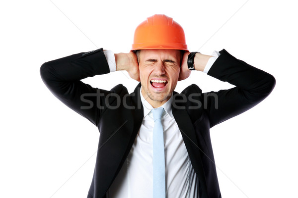 Businessman in helmet covering his ears over white background Stock photo © deandrobot
