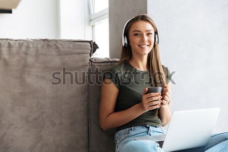 Happy woman sitting on the bed with remote control Stock photo © deandrobot