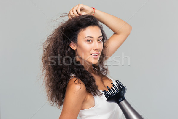 Portrait of attractive woman dries her hair Stock photo © deandrobot