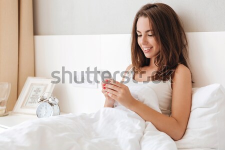 Woman with hairdryier sitting on the bed Stock photo © deandrobot