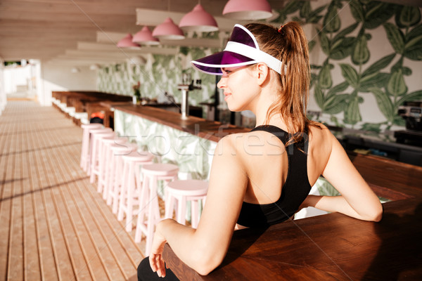 Sports woman resting after workout in a beach cafe Stock photo © deandrobot