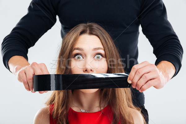 Closeup of man covering woman mouth by black tape Stock photo © deandrobot