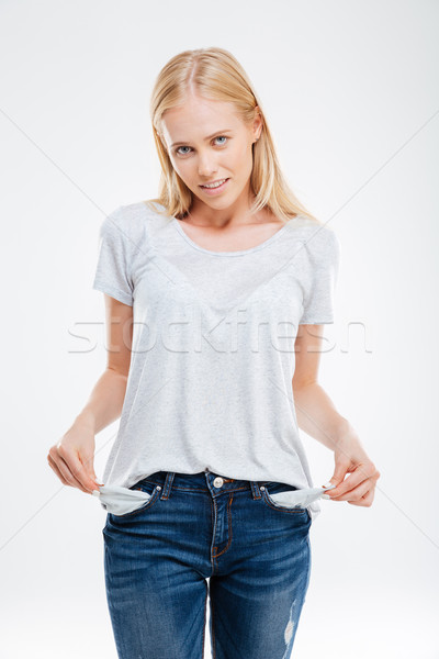 Sad young woman showing empty pockets Stock photo © deandrobot